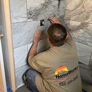 HomeWorks cgo employee installing grout in a shower