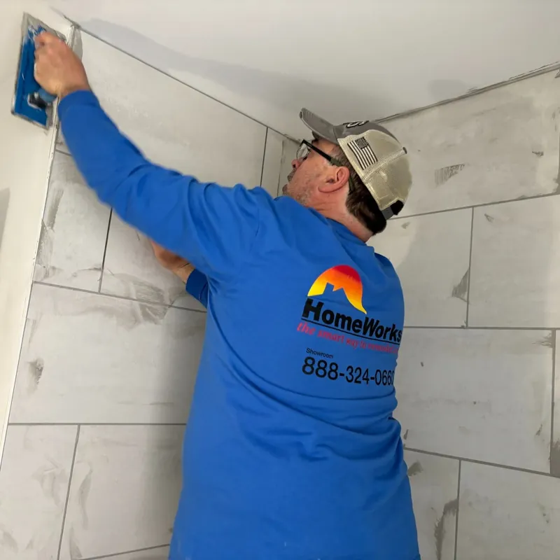 HomeWorks employee working on a tiled shower
