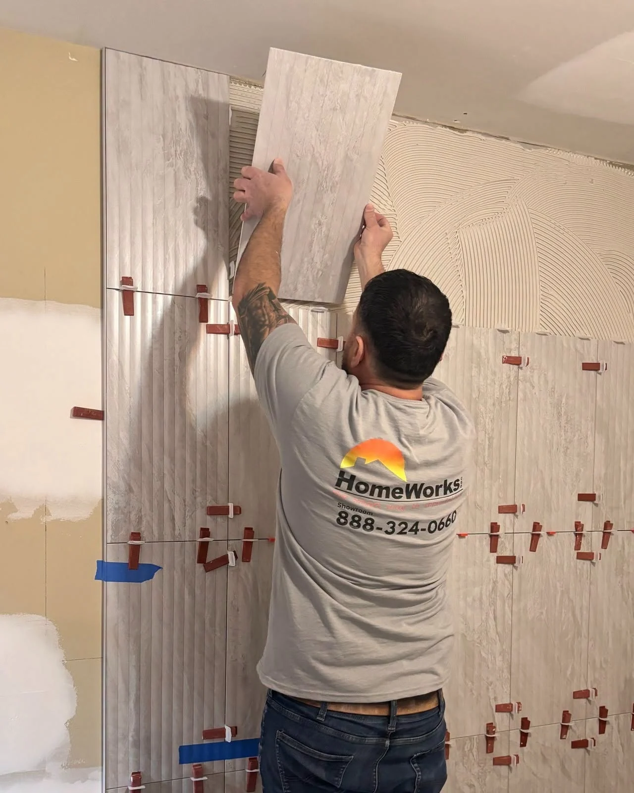 HomeWorks employee working on a tiled shower